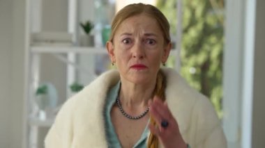 Umutsuz bir yüz ifadesiyle kırışıklıklara bakan umutsuz orta yaşlı bir kadının aynadaki görüntüsü. Kafkasyalı üzgün kadının evdeki portresi. Yaşlanma ve yaşam tarzı kavramı.