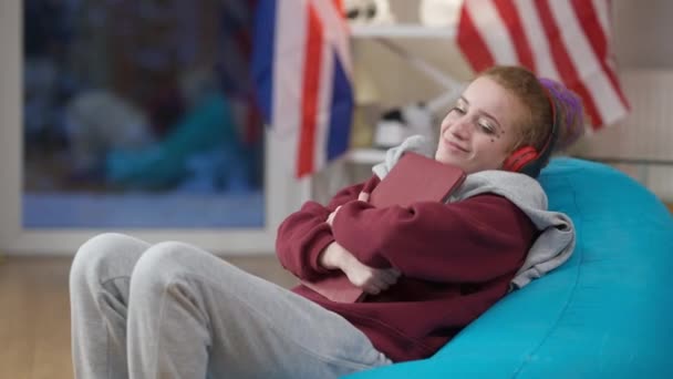 Tevreden jonge blanke vrouw die laptop knuffelt, geeuwt en thuis in slaap valt op een stoel. Portret van overwerkte freelancer die thuis slaapt over werken op afstand. Nieuw normaal concept. — Stockvideo