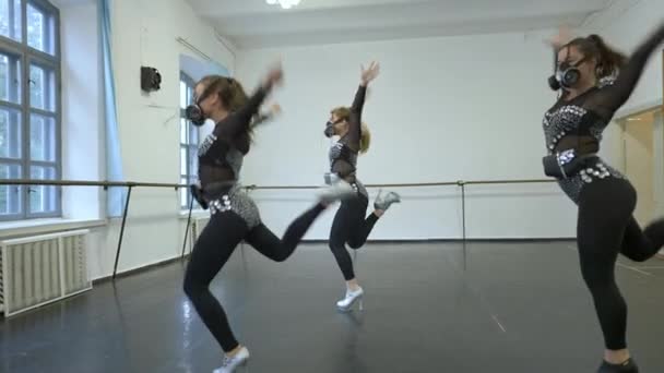 Tres bailarines modernos que realizan una danza extravagante en trajes brillantes con respiradores. Amplio plano de mujeres caucásicas profesionales ensayando actuación en estudio de baile. Concepto artístico. Cámara en vivo. — Vídeo de stock