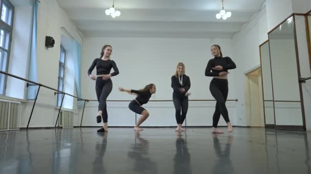 Wide shot talented modern ballet dancers jumping in slow motion rehearsing dance in studio indoors. Slim confident beautiful Caucasian young women dancing. Performance and art concept. — Stock Video