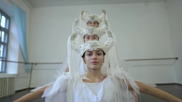 Portret pewnej siebie młodej pięknej kobiety poruszającej się w zwolnionym tempie z przyjaciółmi tańczącymi w białym kostiumie. utalentowani, utalentowani, kaukascy tancerze ćwiczący w studio w pomieszczeniach. — Wideo stockowe