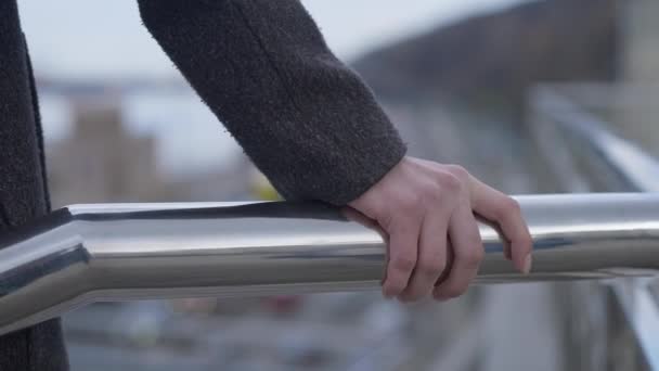 Vrouwelijke handgreep brug leuning met wazig weg aan de onderkant. Onherkenbare jonge blanke suïcidale vrouw die probeert naar beneden te springen. Zelfmoord en crisisconcept. — Stockvideo