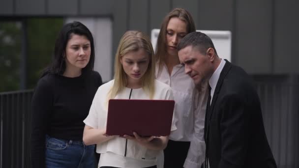 Medium shot van jonge blanke vrouw controleren e-business succes met een groep collega 's. Portret van blije enthousiaste zakenmensen die in slow motion een overwinningsgebaar maken, Succes concept. — Stockvideo