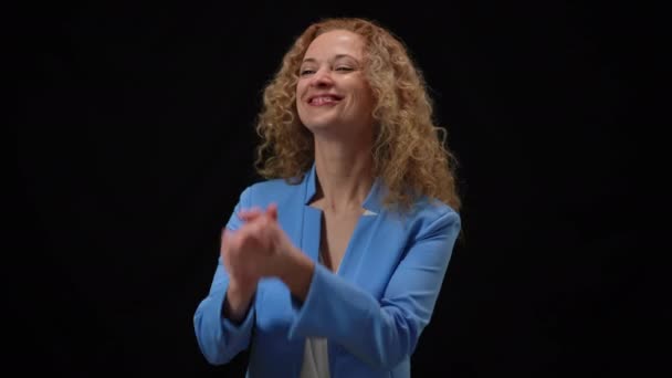 Šťastná žena drží ruce u sebe a děkuje za potlesk. Portrét sebevědomého úspěšného usmívajícího se bělošského politika v záblescích fotoaparátu na černém pozadí děkování publiku a tisku — Stock video