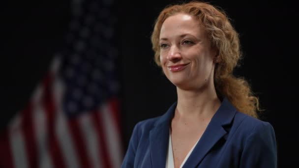 Confident politician woman shaking head listening to opponent arguments on debates. Portrait of elegant inspired diplomat campaigning with American flag at black background. — Stock Video