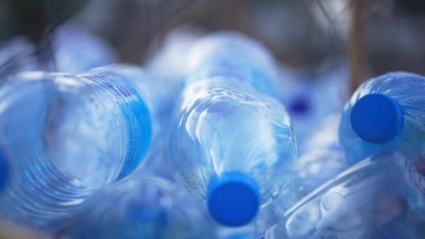 Tomma plastflaskor som ligger utomhus på solig dag. Staplat skräp på nära håll. Begreppet miljöskydd och miljöförstöring. — Stockvideo