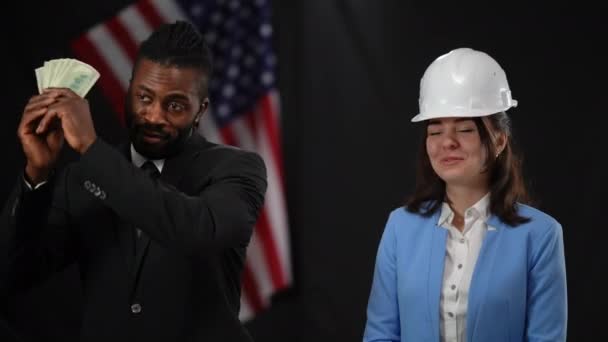 Africký americký politik předává peníze bělošce v klobouku v záblescích kamer. Důvěryhodný muž, který vede kampaň na podporu stavebního průmyslu. Koncept voleb. — Stock video