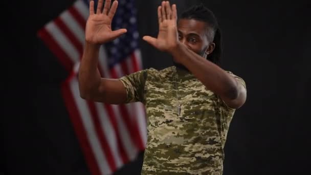 Retrato do porta-voz militar afro-americano cumprimentando o público em flashes de câmera agradecendo por ter vindo. Sério homem confiante na conferência de imprensa com a bandeira dos EUA em fundo preto. Patriotismo. — Vídeo de Stock