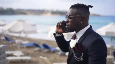 Kızgın Afro-Amerikalı şık takım elbiseli adam güneşli bir günde telefonda tartışıyor. Gergin damat akıllı telefonda konuşuyor. Gelin geç kalıyor. Nöbet saatini kontrol ediyor..