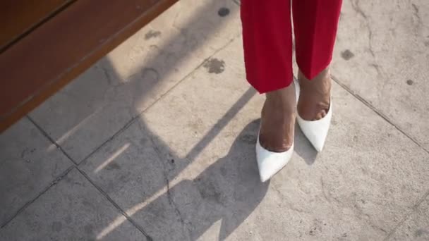 Hoge hoek uitzicht vrouwelijke voeten in witte hoge hakken tikken snel en lopen weg. Onherkenbare slanke stijlvolle blanke vrouw in modieuze schoenen vertrekken op zonnige zomerdag buiten. — Stockvideo