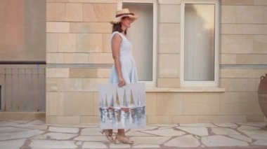 Yavaş çekimde gülümseyen mutlu bir kadının yan görüntüsü. Güzel ince, zarif Kafkas ressamın açık havada sanat eserleriyle gezdiği geniş bir çekim. Yaşam tarzı ve mutluluk.