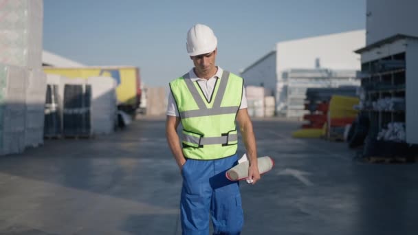 Znepokojený muž z Blízkého východu v klobouku, kráčející ve zpomaleném filmu po venkovním skladišti a házející plány a odcházející. Portrét zklamaného smutného pohledného inženýra rozrušeného výsledky práce. — Stock video