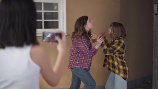 Kavkazské dospívající dívka kouřící online boj naštvaných spolužáků venku. Natáčení přes rameno rozmazané teenager natáčení na smartphone konfliktu agresivních dospívajících dívek bojujících. — Stock video