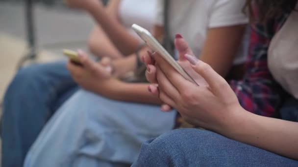 10代の女の子のクローズアップ手は、屋外の街の通りに座ってスマートフォンで高速テキストメッセージ。認識できないデバイス中毒吸収白人のティーンエイジャーは、ソーシャルメディアでオンラインメッセージング. — ストック動画
