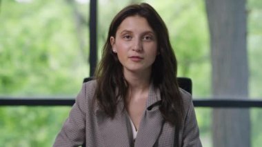 Kameraya bakarak görüntülü konuşma yapan kendine güvenen bir kadının portresi. Uzaktan kumandalı iş arkadaşlarıyla çevrimiçi beyin fırtınası yapan Kafkas kadın yöneticisinin ön görüntüsü.