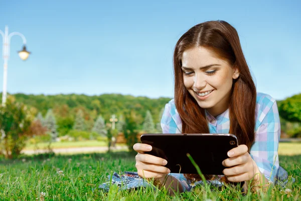 Hermosa chica en el parque con touchpad — Foto de Stock