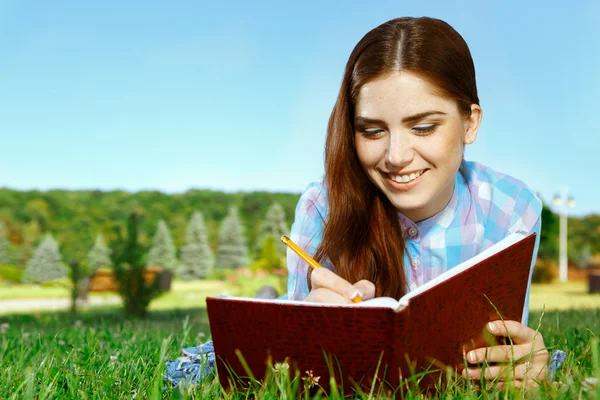 Mooi meisje in park met haar dagboek — Stockfoto