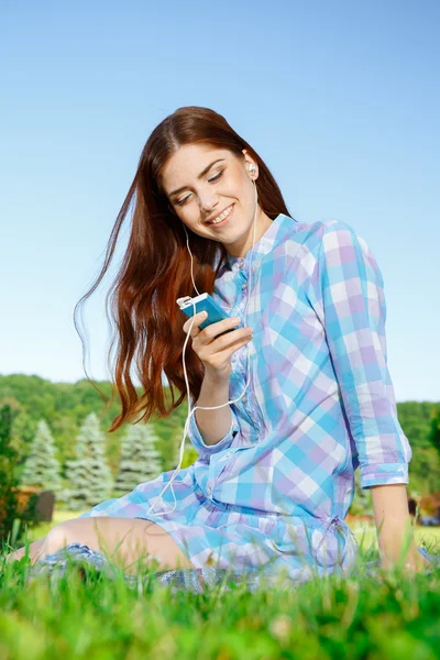 Hermosa chica en el parque con su teléfono — Foto de Stock