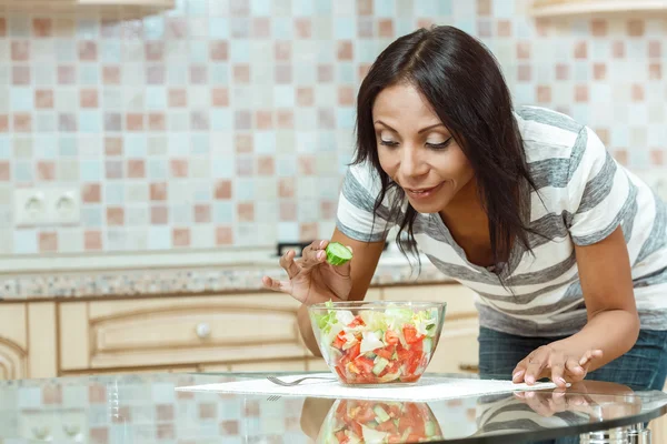 Vacker kvinna äta färsk sallad i moderna kök — Stockfoto