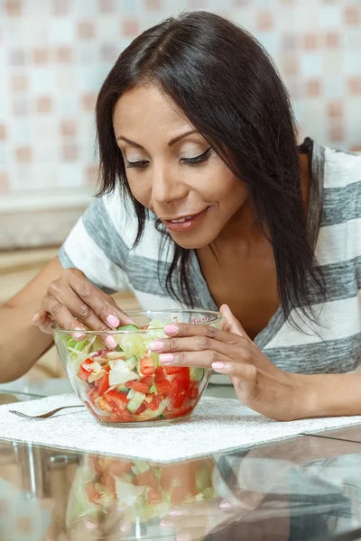 Vacker kvinna äta färsk sallad i moderna kök — Stockfoto