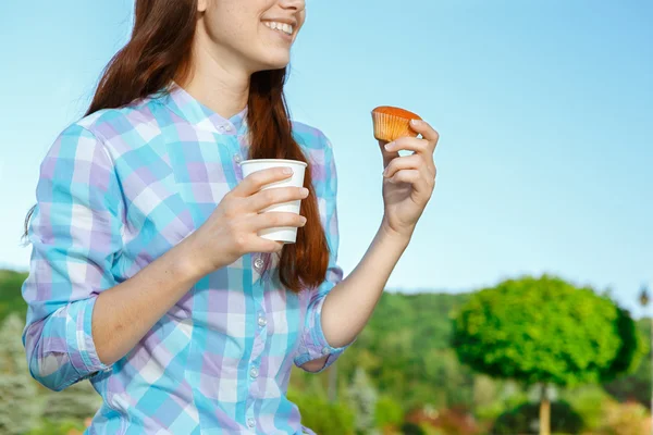 Vacker ung flicka med tårta och kaffe i parken — Stockfoto