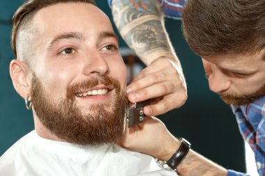 Tıraş sırasında gülümseyen bir hipster portresi