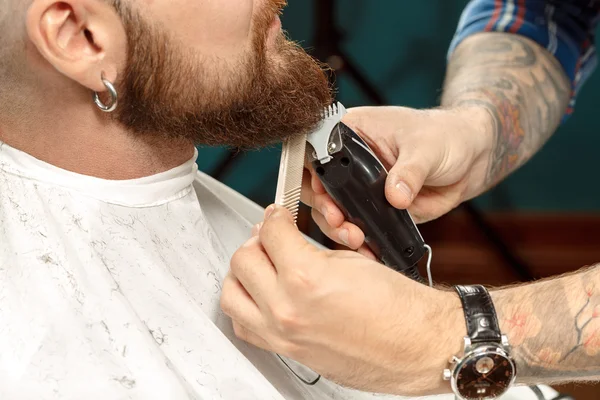 Um homem bonito a rapar a barba numa barbearia. — Fotografia de Stock