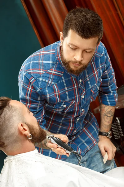 Un hombre guapo afeitándose la barba en una peluquería —  Fotos de Stock