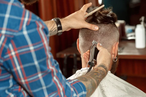 Bonito homem recebendo novo corte de cabelo em uma barbearia — Fotografia de Stock