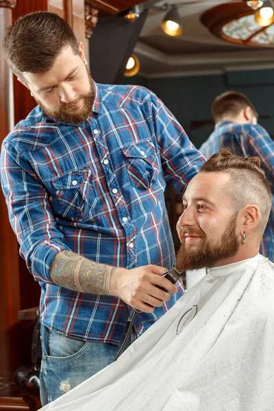Handsome man getting his beard shaved in a barber shop — Stock Photo, Image