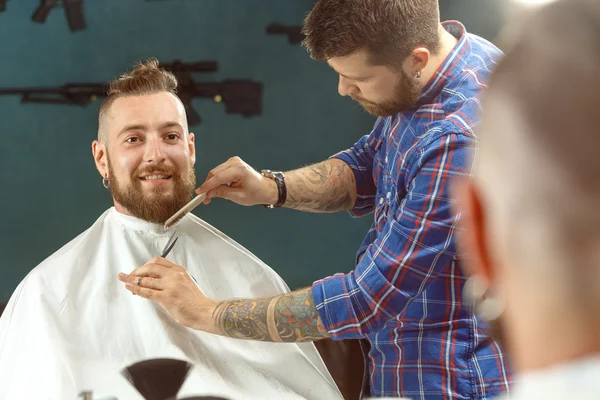 Un hombre guapo afeitándose la barba en una peluquería —  Fotos de Stock