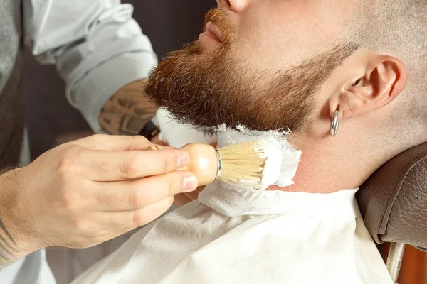 Halssåpe og barbering i frisørsalong stockbilde