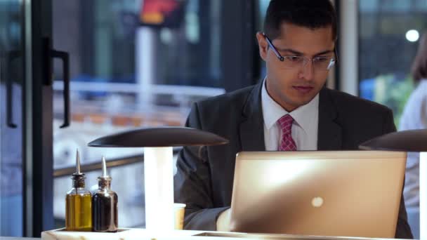 Бізнесмен, що працює з ноутбуком в кафе — стокове відео