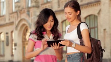 İki sevimli kız web bir tablet üzerinde sörf