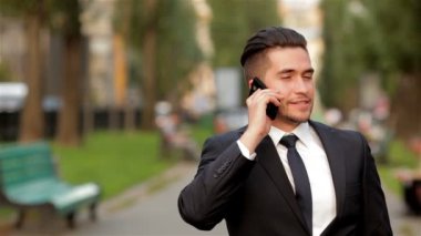 Genç işadamı cep telefonuyla konuşuyor.