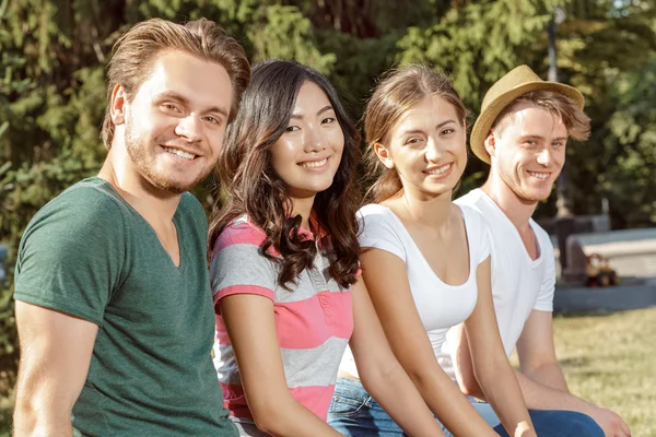 Fyra elever varmt leende in i kameran — Stockfoto