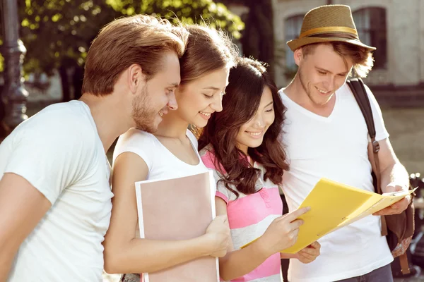 Studenten kijken naar boeken wandelen in het park — Stockfoto