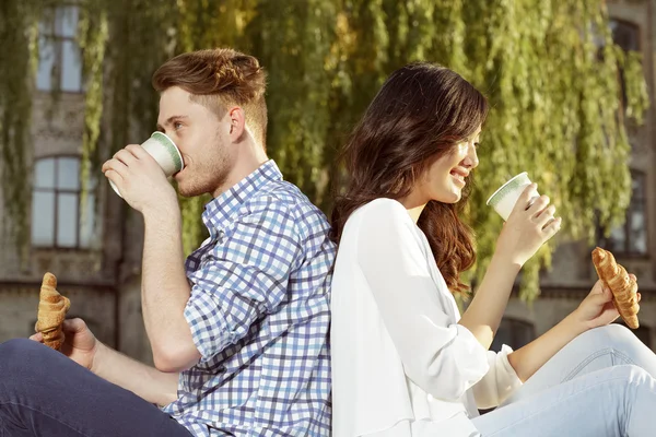 Par de estudante bonito beber café e comer croissants — Fotografia de Stock