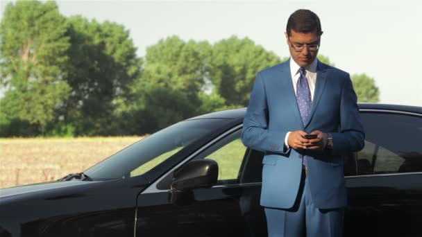 Jonge zakenman roepen op de telefoon naast auto — Stockvideo