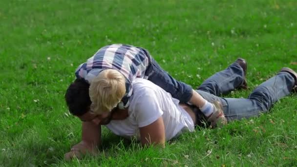 父亲和儿子在公园的草地上玩耍 — 图库视频影像