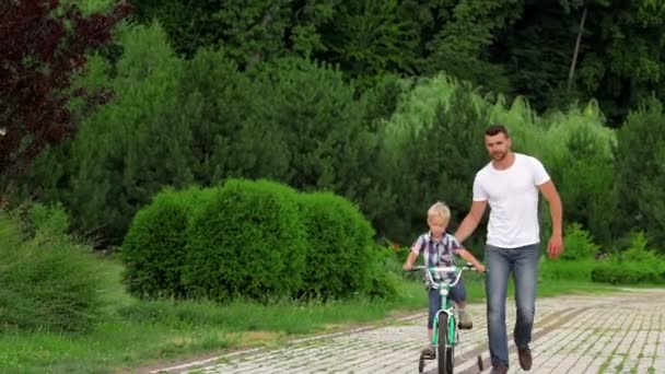 Father teaching his son to ride a bike — Stock Video