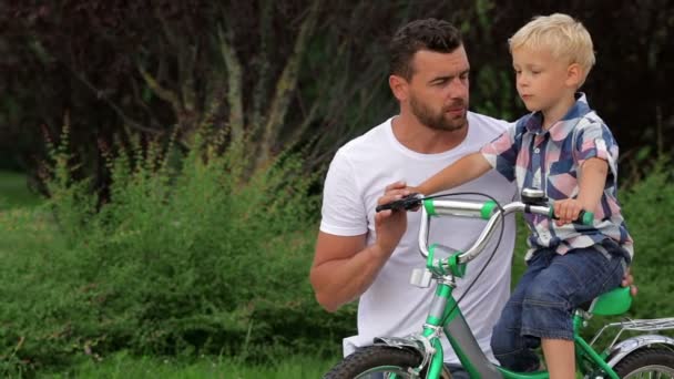 Pai ensinando seu filho a andar de bicicleta — Vídeo de Stock