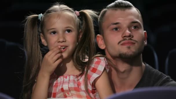 Frère aîné et petite sœur regardent un film — Video