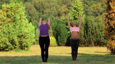 Yeşil çimlerde yoga yapan kadın.