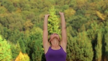 Yeşil çimlerde yoga yapan kadın.