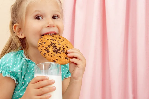 Çikolatalı kurabiye ve süt ile neşeli küçük kız