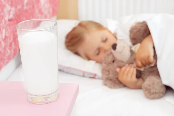 Søt liten jente som sover i senga med bamsen sin royaltyfrie gratis stockfoto