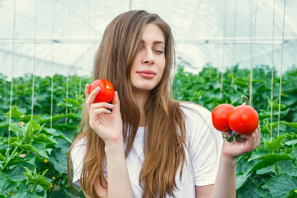 Mooi meisje landbouwer bedrijf tomaat — Stockfoto