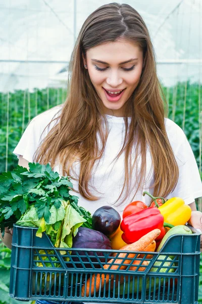 Flicka som håller en låda med ekologiska grönsaker. — Stockfoto
