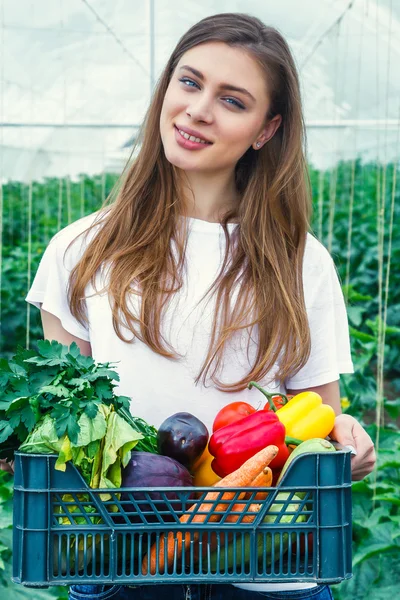 Flicka som håller en låda med ekologiska grönsaker. — Stockfoto